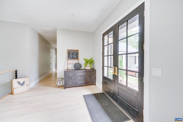 entrance foyer featuring light wood-type flooring, french doors, and a wealth of natural light