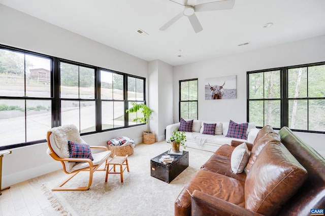 living room with wood-type flooring, ceiling fan, and a healthy amount of sunlight