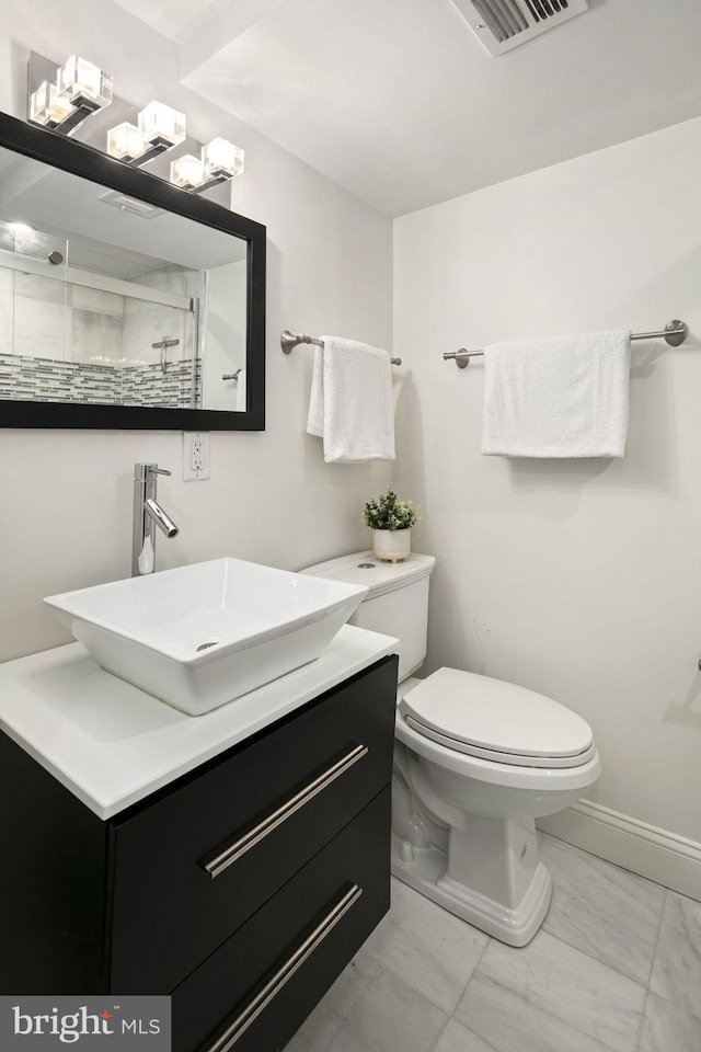 bathroom with walk in shower, vanity, and toilet