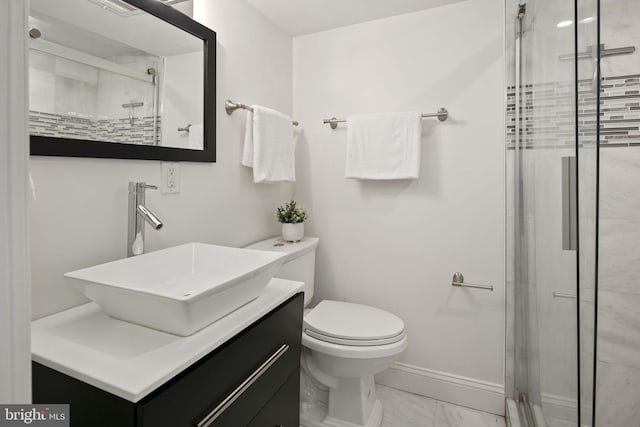 bathroom featuring vanity, a shower with shower door, and toilet