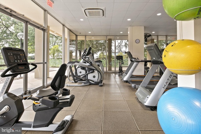 gym featuring a drop ceiling and floor to ceiling windows