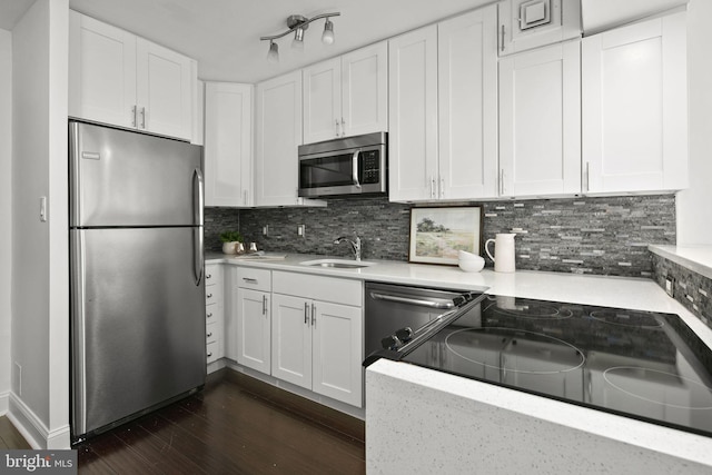 kitchen with white cabinets, stainless steel appliances, dark hardwood / wood-style flooring, and decorative backsplash