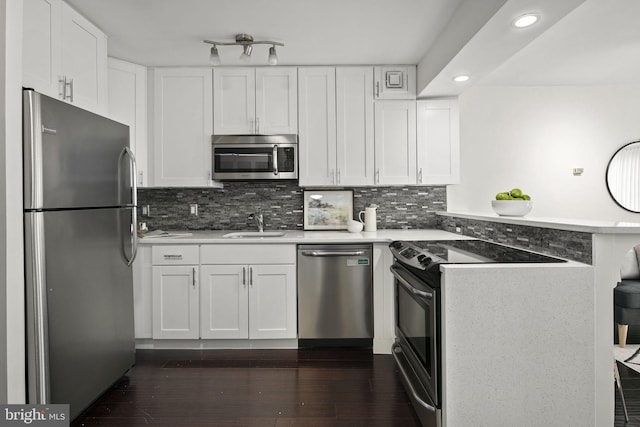 kitchen with decorative backsplash, stainless steel appliances, white cabinets, and dark wood-type flooring