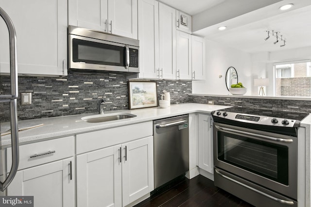 kitchen featuring dark hardwood / wood-style floors, sink, white cabinetry, stainless steel appliances, and backsplash