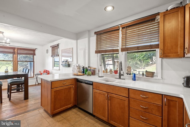 kitchen with light hardwood / wood-style floors, sink, kitchen peninsula, and stainless steel dishwasher