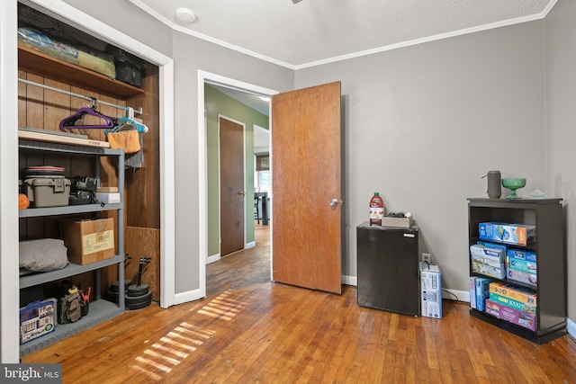 miscellaneous room featuring hardwood / wood-style flooring and crown molding