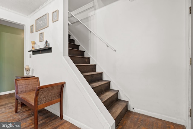 staircase featuring ornamental molding and hardwood / wood-style floors