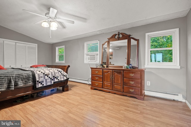 bedroom with baseboard heating, light wood-type flooring, and ceiling fan