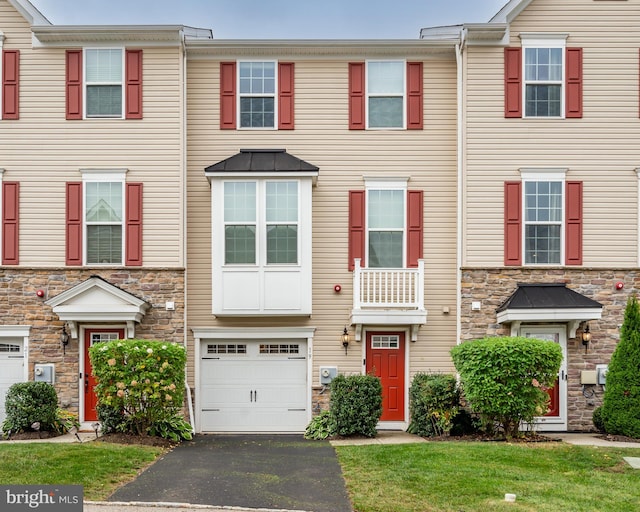 townhome / multi-family property with a garage and a front yard