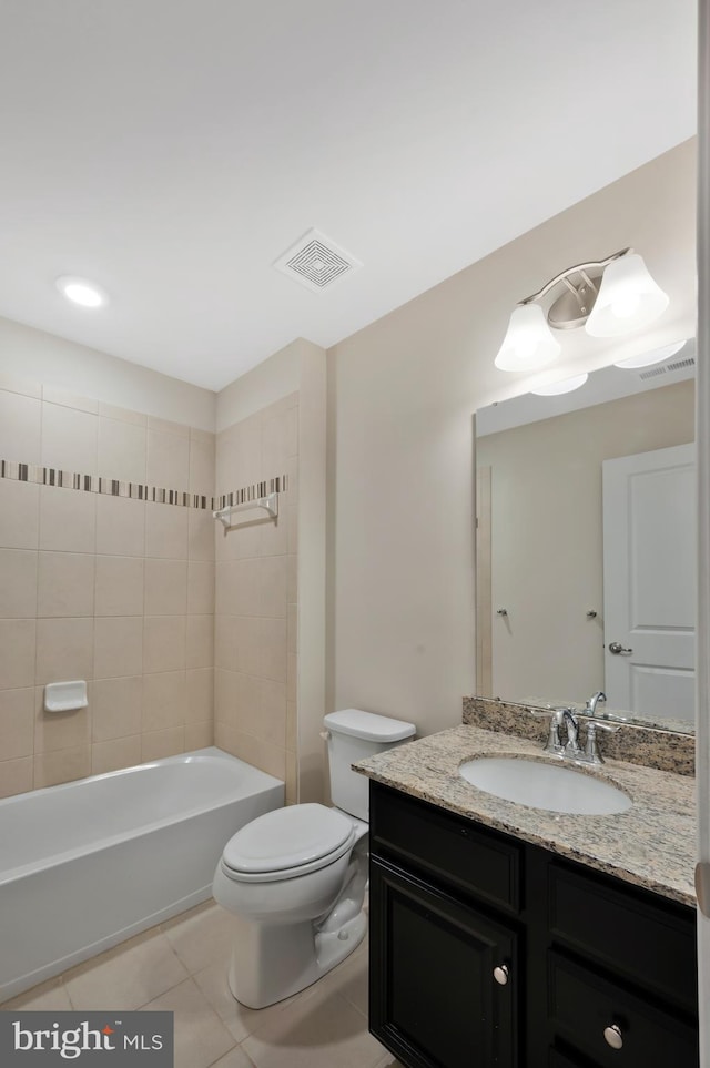 full bathroom featuring tile patterned floors, tiled shower / bath, vanity, and toilet