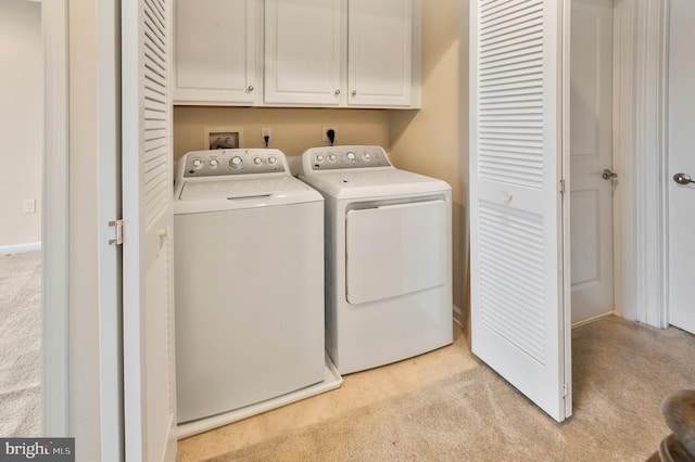 washroom with light carpet, independent washer and dryer, and cabinets