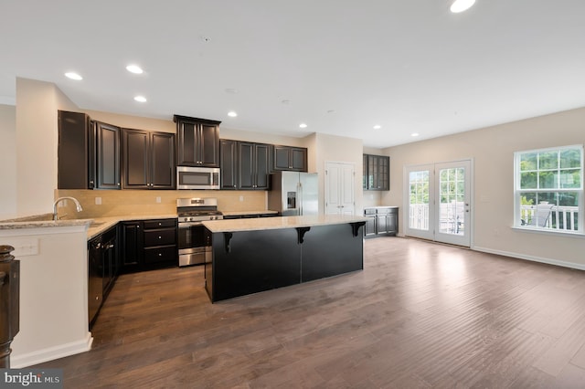 kitchen featuring wood-type flooring, stainless steel appliances, and a kitchen island