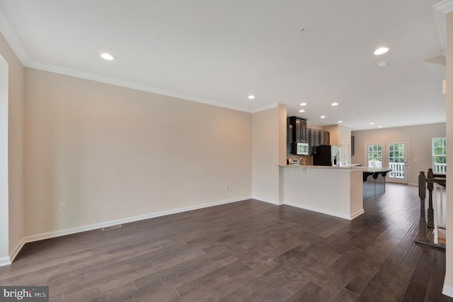 unfurnished living room featuring ornamental molding and dark hardwood / wood-style floors