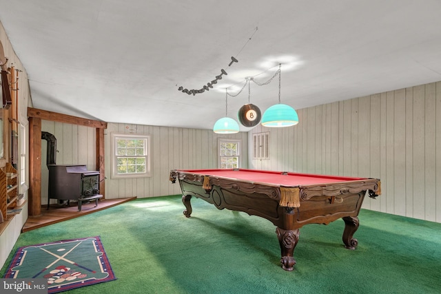 playroom featuring wood walls, carpet flooring, a wood stove, rail lighting, and lofted ceiling