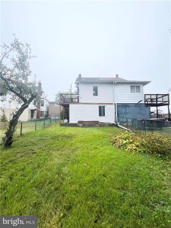 rear view of house with a lawn and a deck