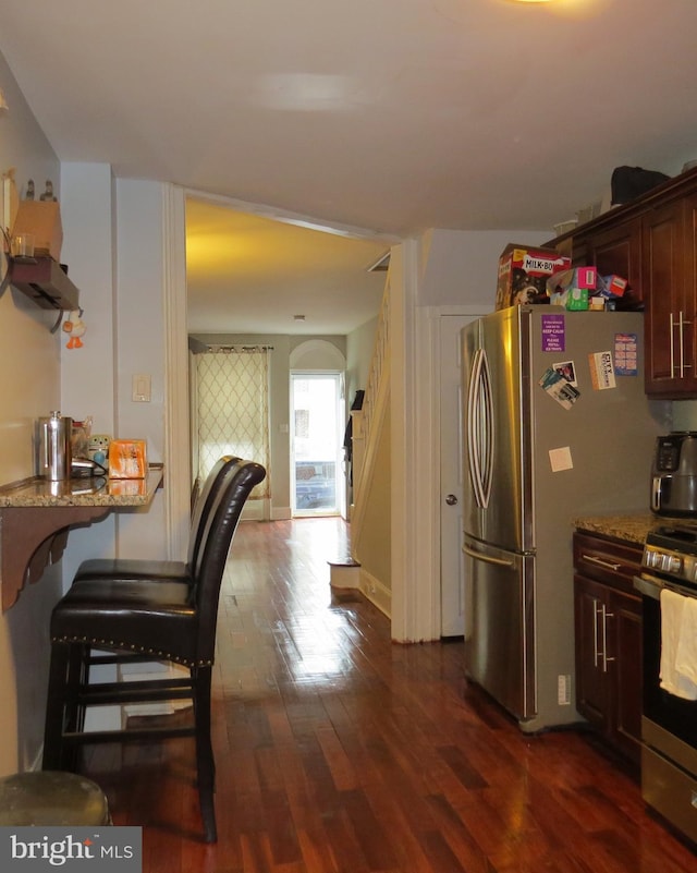 kitchen featuring light stone countertops, appliances with stainless steel finishes, and dark hardwood / wood-style floors