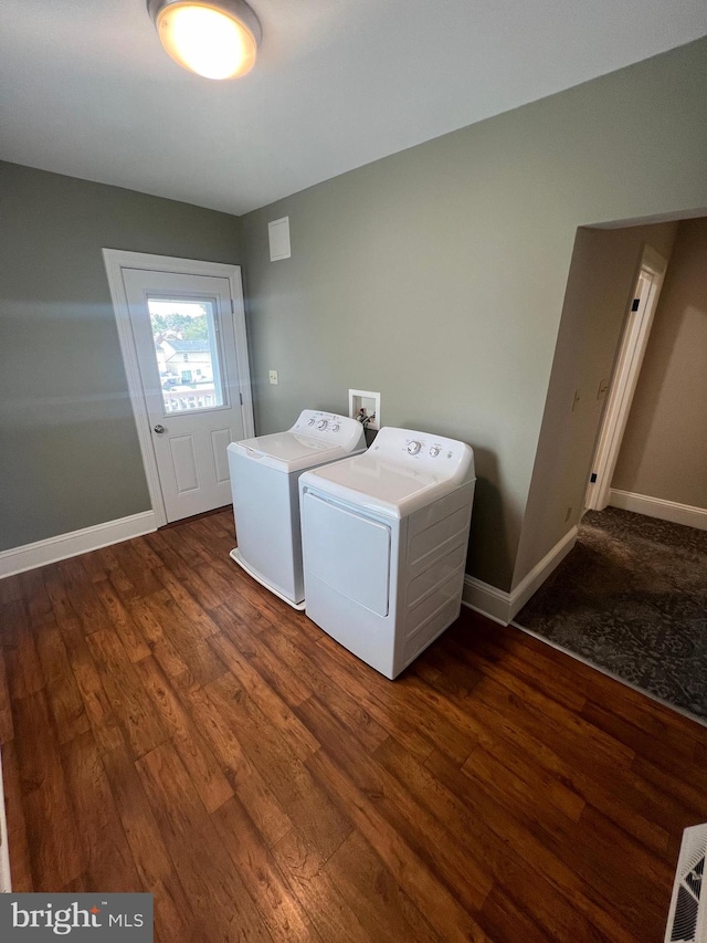 laundry room with washing machine and clothes dryer and dark hardwood / wood-style floors