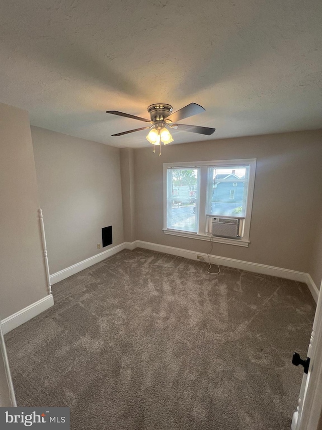 unfurnished room with a textured ceiling, cooling unit, dark colored carpet, and ceiling fan