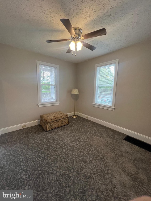 unfurnished room with carpet flooring, ceiling fan, and plenty of natural light