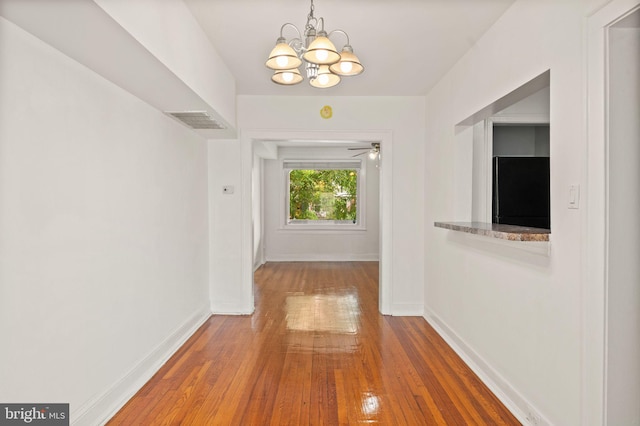 hall with a chandelier and hardwood / wood-style floors