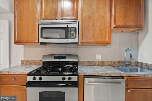 kitchen featuring stainless steel appliances, backsplash, and sink