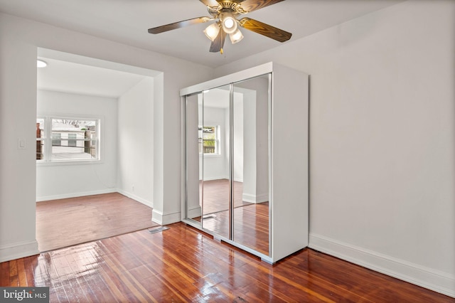 unfurnished bedroom featuring a closet, ceiling fan, and hardwood / wood-style flooring