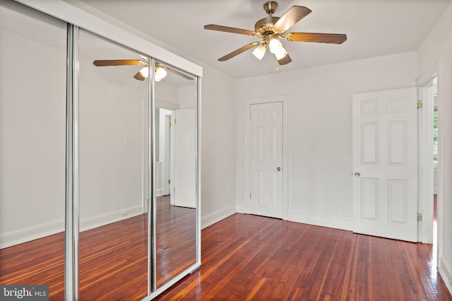 unfurnished bedroom with ceiling fan and dark wood-type flooring