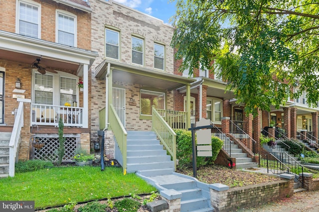 multi unit property with a porch, ceiling fan, and a front yard