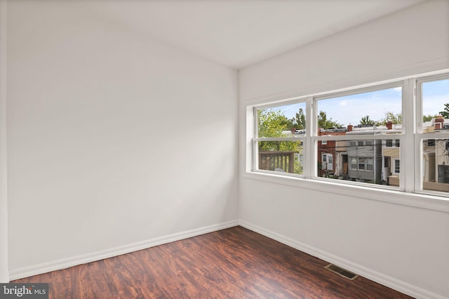 unfurnished room with dark wood-type flooring