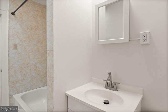 bathroom with tiled shower / bath and vanity