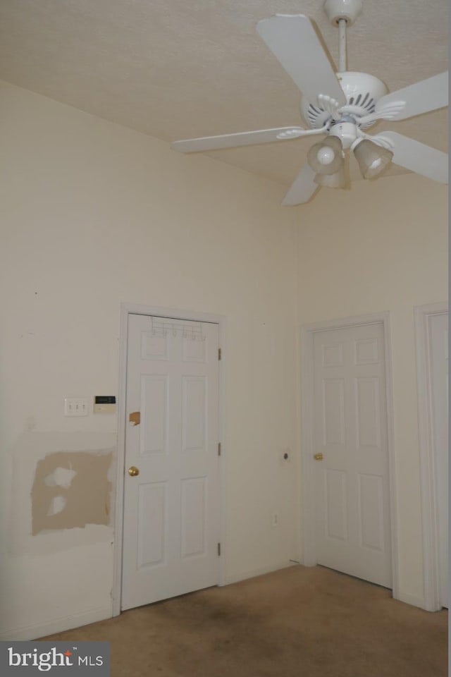 carpeted empty room featuring ceiling fan