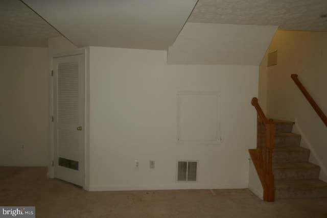 interior space with a textured ceiling and carpet