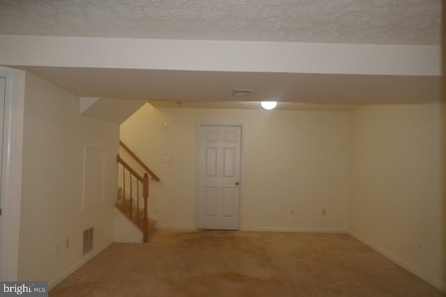 basement with a textured ceiling and carpet flooring