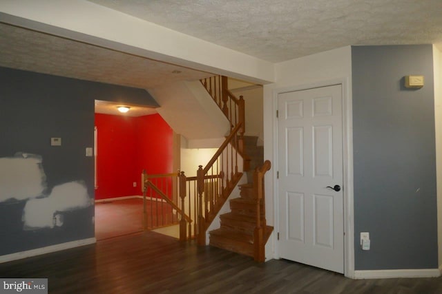 stairway featuring a textured ceiling and hardwood / wood-style flooring