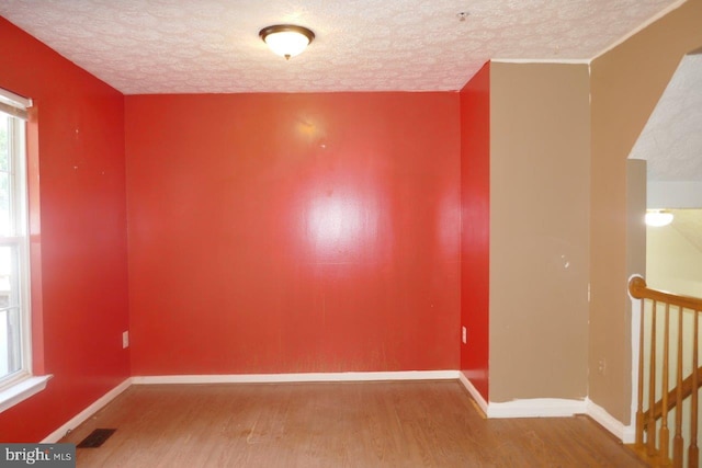 empty room featuring hardwood / wood-style flooring and a textured ceiling