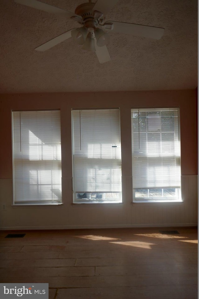 interior space featuring a textured ceiling, ceiling fan, and hardwood / wood-style flooring