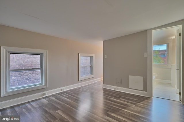 empty room with dark hardwood / wood-style flooring