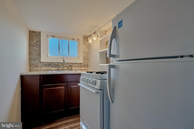 kitchen with dark brown cabinets, dark hardwood / wood-style floors, sink, decorative backsplash, and white appliances