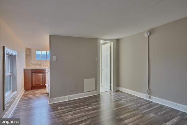 unfurnished room with dark wood-type flooring