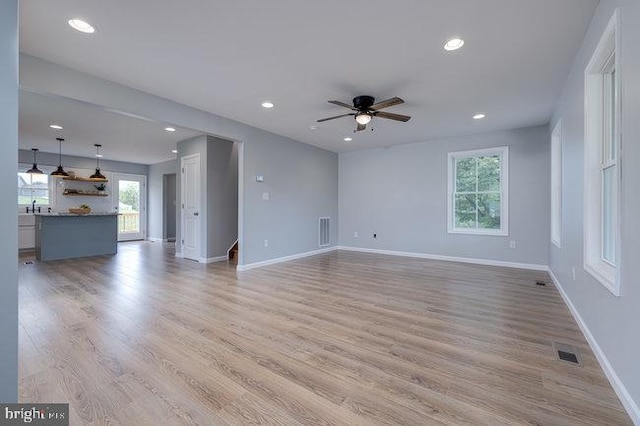 unfurnished living room with ceiling fan, plenty of natural light, and light hardwood / wood-style floors