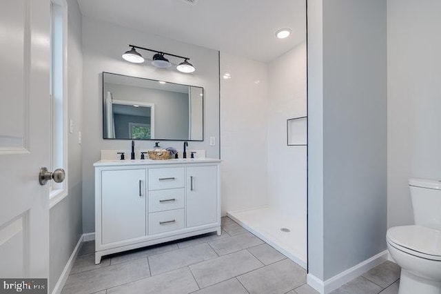 bathroom featuring a shower, vanity, toilet, and tile patterned floors