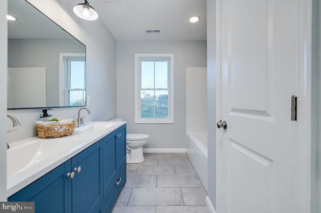 bathroom with a bath, vanity, toilet, and tile patterned floors