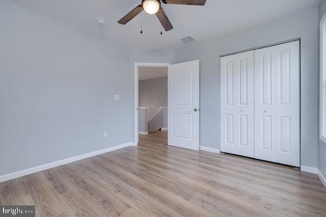 unfurnished bedroom with ceiling fan, light hardwood / wood-style flooring, and a closet