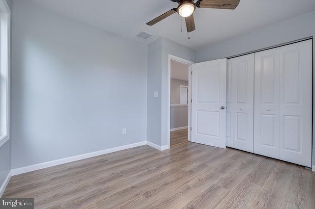 unfurnished bedroom featuring ceiling fan, light wood-type flooring, and a closet