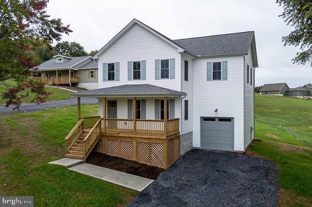 view of front of home with a front yard, a porch, and a garage