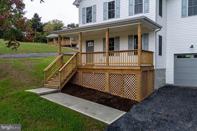 view of front of property featuring a front yard, a garage, and covered porch