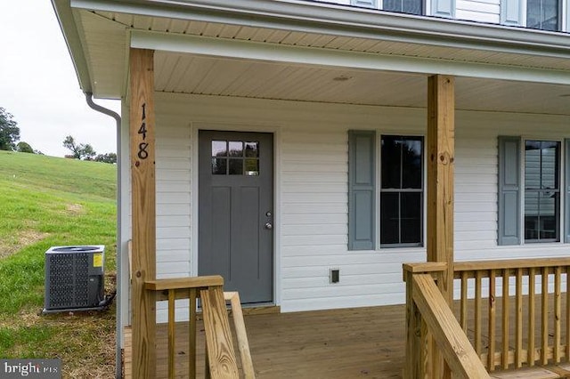 doorway to property with covered porch and central air condition unit