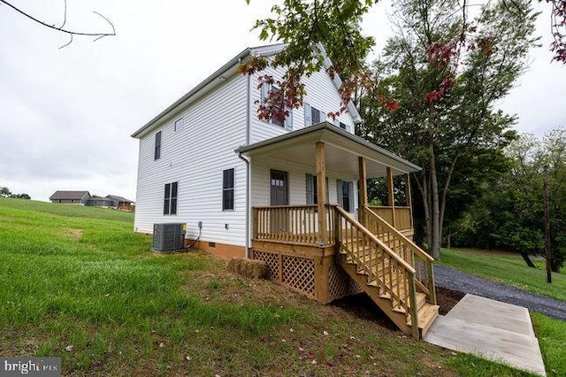 rear view of house featuring a yard, a porch, and central AC unit