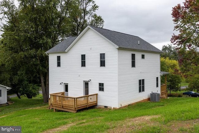 rear view of property with a deck, a yard, and central air condition unit