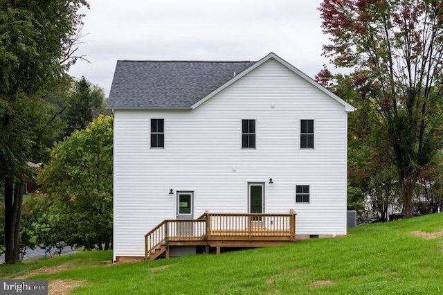 rear view of house with a deck and a yard